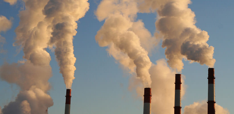 Multiple smokestacks billowing smoke into the air