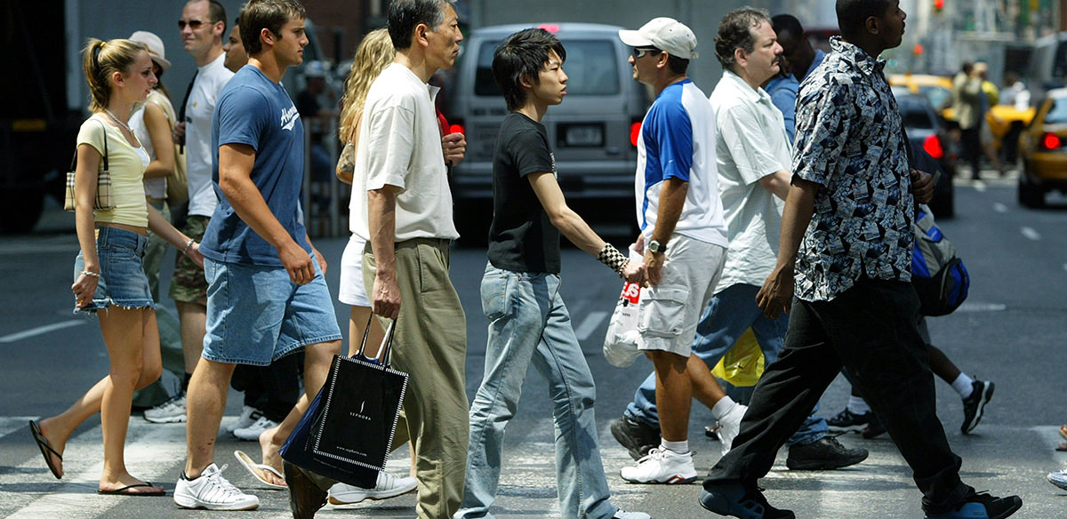 Several people crossing the street in a city